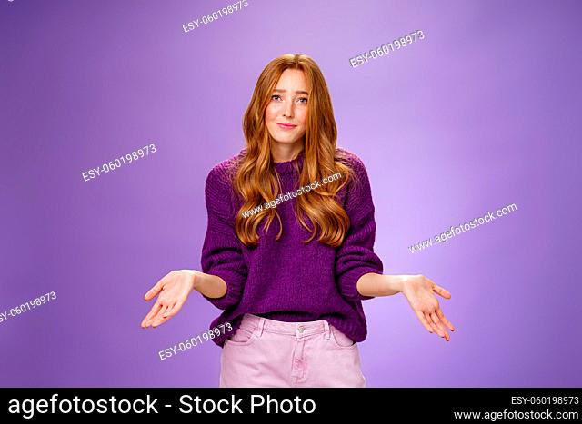 Who cares chill I not know. Portrait of clueless and unbothered cute redhead female in purple sweater smirking in sorry and shrugging with hands sideways being...