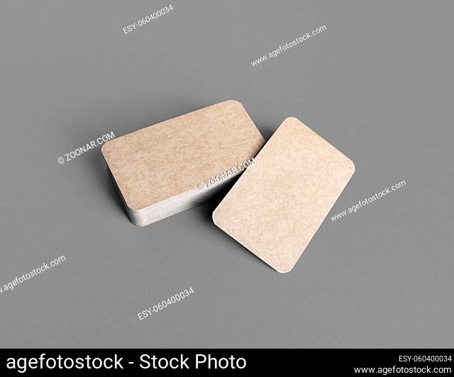 Photo of blank kraft business cards on gray paper background. Mock-up for branding identity