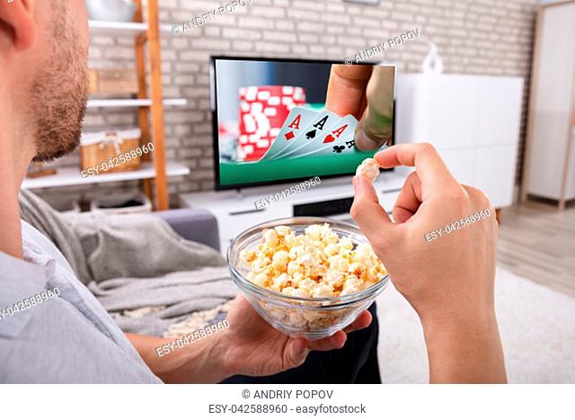Close-up Of A Man With Bowl Of Popcorn Watching Television At Home
