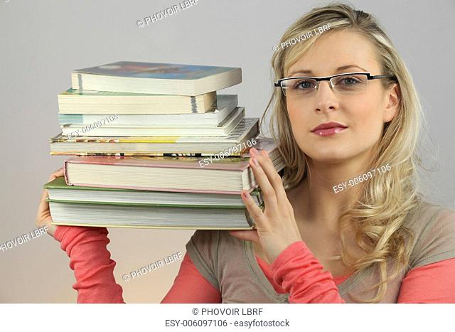 Attractive blond carrying pile of books