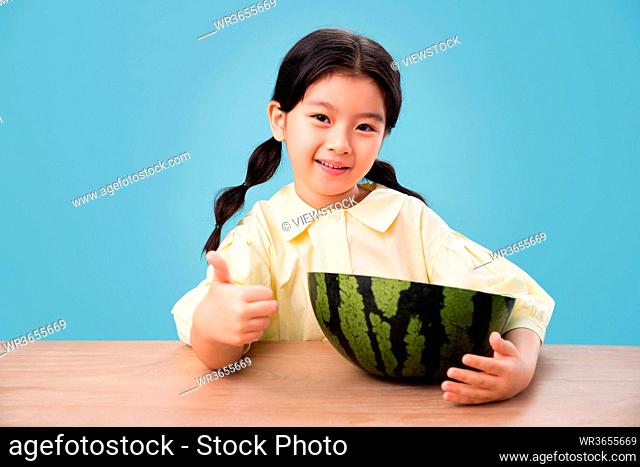 Lovely little girl eating watermelon