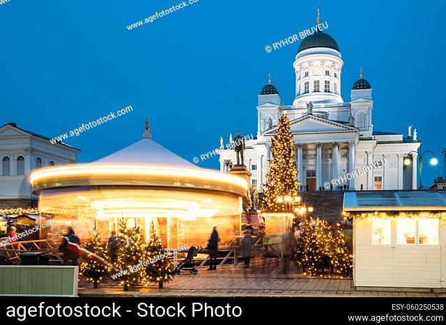 Helsinki, Finland. Christmas Xmas Holiday Carousel On Senate Square Near Famous Landmarks. Lutheran Cathedral And Monument To Russian Emperor Alexander II At...