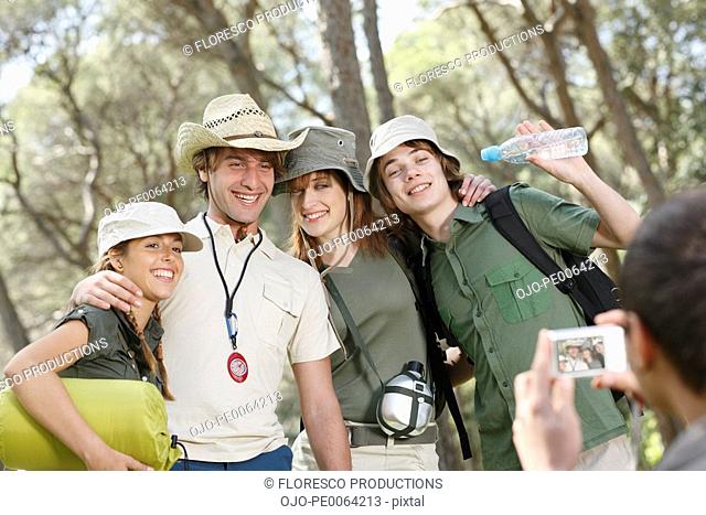 Friends posing for photograph in forest