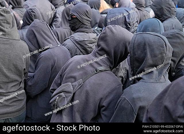 01 May 2021, Berlin: Participants walk through the city in black hoodies during the demonstration procession of left-wing and radical left-wing groups under the...