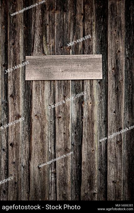 Old wooden wall with a wooden sign