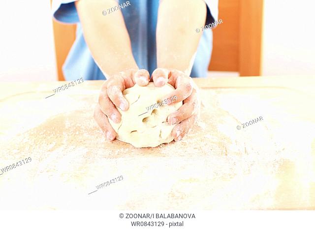 Details of children's hands kneading dough