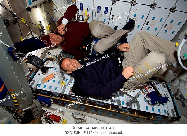 Astronauts Ron Garan (bottom) and Mike Fossum, both STS-124 mission specialists, are pictured near the galley on the middeck of Space Shuttle Discovery during...