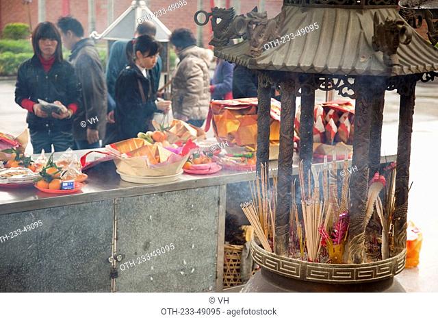 A worshipper offering at the buddhist temple, Shantou, China