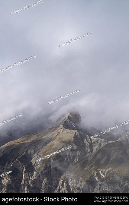 30 September 2017, Austria, Drei Zinnen: View of a mountain peak surrounded by clouds north of the Three Peaks (Italy). The mountain range belongs to the Sesto...