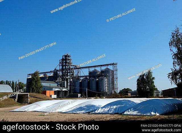 PRODUCTION - 28 September 2023, Ukraine, Kiew: Large sacks of wheat lie in front of the high silo and drying plant of the German company UIFK Agro in the...