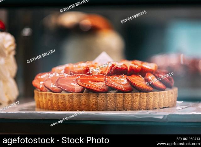 pie with strawberries, assortment baked pastry in bakery. Various Different Types Of Sweet Cakes In Pastry Shop Glass Display