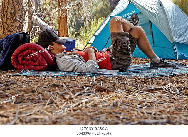 Young male camper resting in forest, Los Angeles, California, USA
