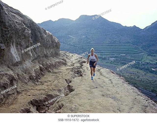 Woman running up volcanic hillside VulcanoVulcano is apart from Stromboli the Eolian island with the most recent volcanic activity eruption of 1888-1890 It...