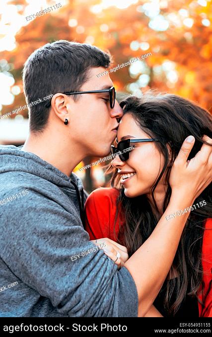 Attractive couple lovers kiss in a park, during a romantic dating outdoors