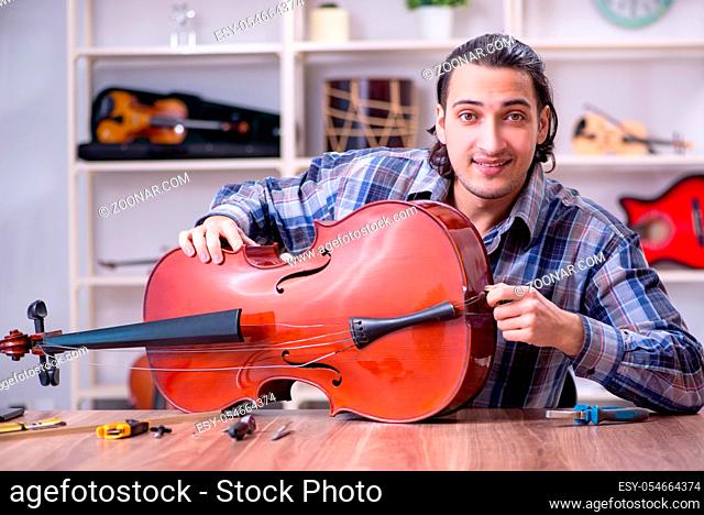 The young handsome repairman repairing cello
