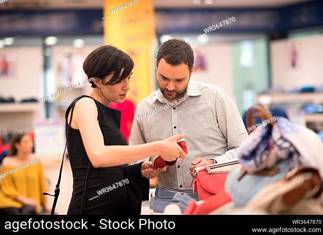 A young attractive couple changes the look with new shoes At Shoe Store