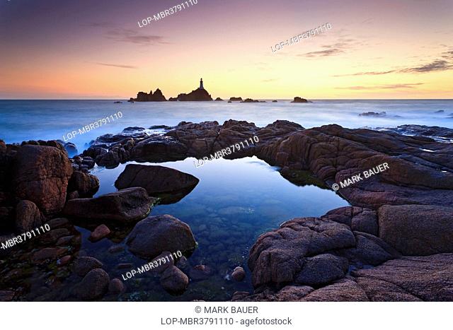 Channel Islands, Jersey, St Brelade. La Corbiere Lighthouse, the first in the British Isles to be built from concrete, at sunset