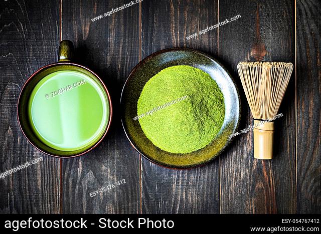 Japanese matcha green tea in a cup and tea powder top view close-up