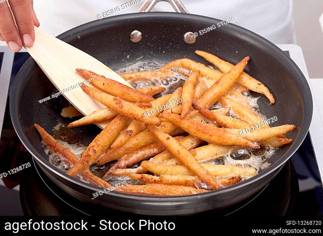 Finger pasta being fried in butter