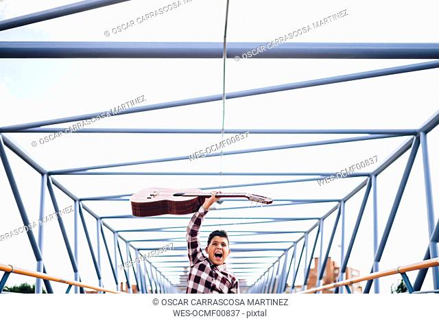 Gypsy boy with guitar on a bridge