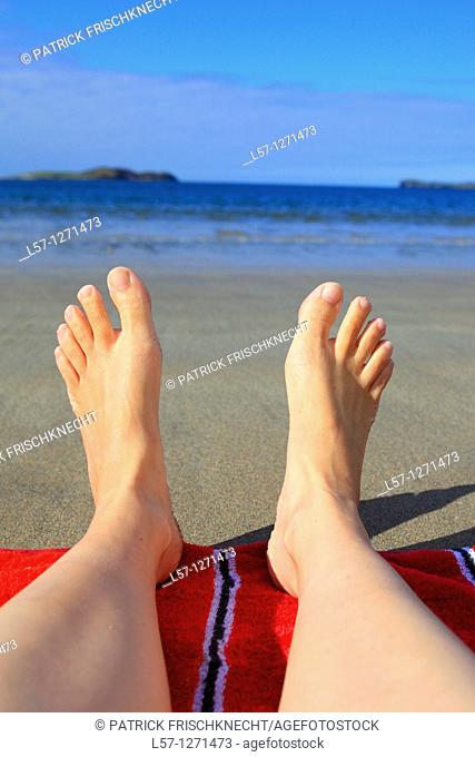 women lying on sandy beach, Sutherland, Scotlandd