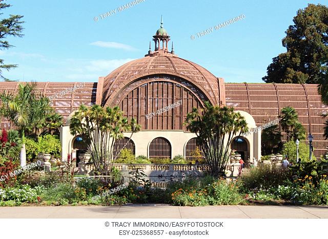 Front view of the Botanical Building with pond, flowers, shrubs and trees framing the building in Balboa Park, San Diego, California, USA