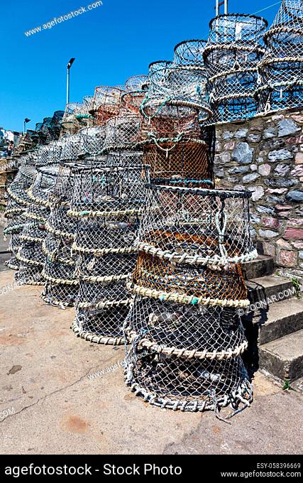 Lobster pots stacked against the harbour wall in Brixham