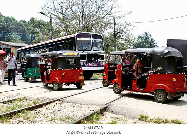 RED TUC TUCS CROSS RAILWAY TRACK; PERADENIYA, SRI LANKA; 12/03/2013