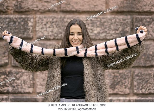 fashionable woman playing with scarf, happy laughing, in Munich, Germany