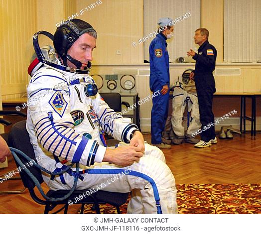 Cosmonaut Sergei K. Krikalev, Expedition 11 commander representing Russia's Federal Space Agency, dons his Russian Sokol spacesuit prior to his launch aboard...