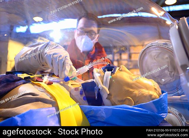 06 January 2021, Saxony, Bautzen: Florian Reifferscheid, head of department, demonstrates treatment on a resuscitation manikin in the ""Epi-Shuttle"" isolation...