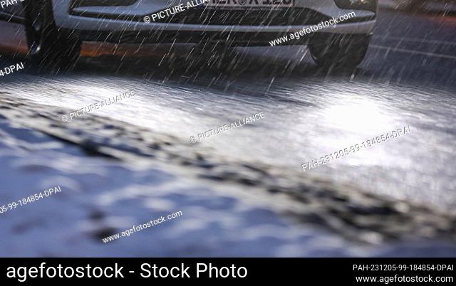 05 December 2023, Saxony, Leipzig: A car drives towards the city center in the morning in the rain and slippery snow. It is expected to continue snowing or...