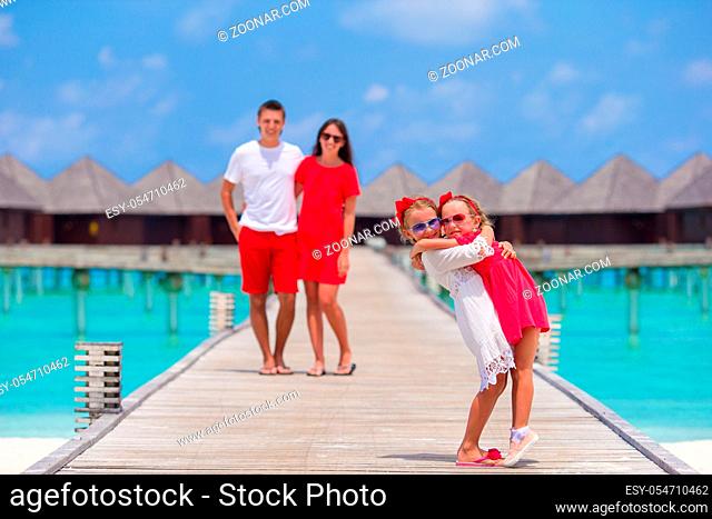 Back view of beautiful family of four on beach during summer vacation