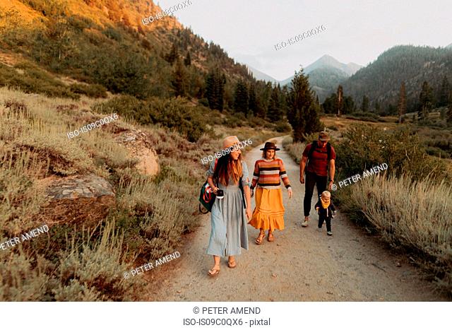 Female toddler with mother and young couple toddling along rural road, Mineral King, California, USA