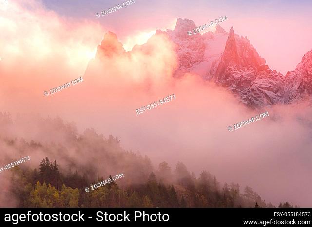 Fantastic evening snow mountains landscape background. Colorful pink and blue clouds overcast sky. French Alps, Europe
