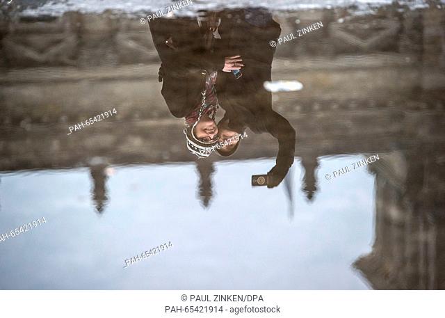 Sienna and Dylan from London are mirrored in a puddle as they take a selfie of themselves in front of the Reichstag building, the seat of the German Bundestag