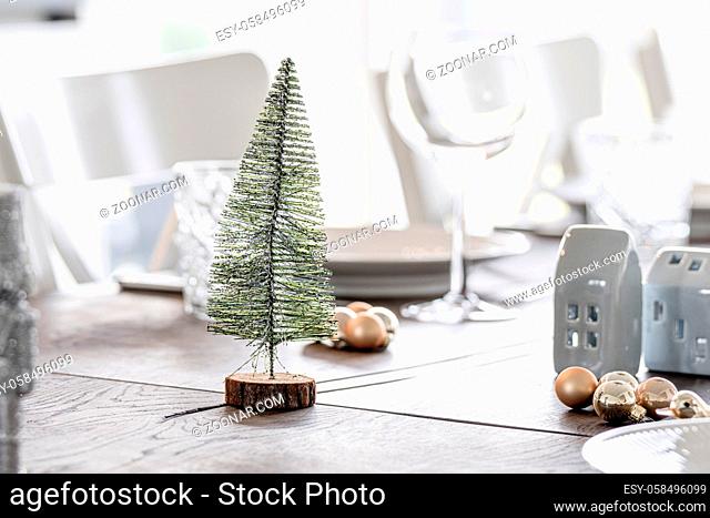 Christmas dinner decoration with a Xmas tree and elegant baubles on a table