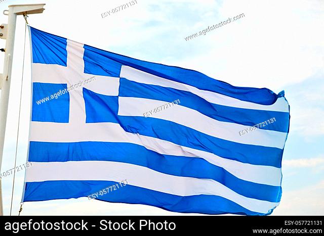 waving greece flag in the  blue sky and   flagpole