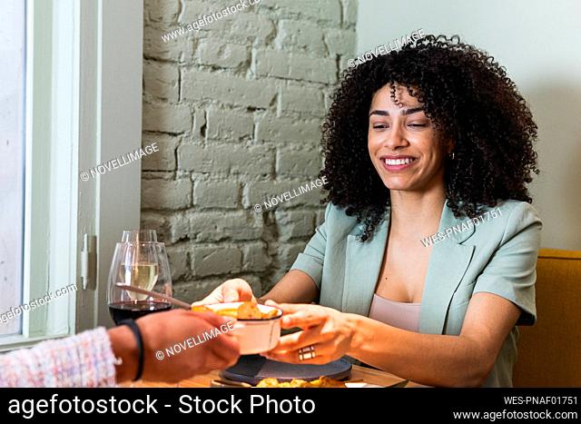 Businesswoman having food with colleague in restaurant