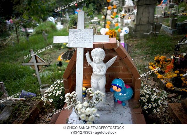 A blue toy and an angel decorate a tomb at the cemetery in Jilotepec cemetery, Xochimilco, Mexico City. The Day of the Dead celebration is a tradition that...