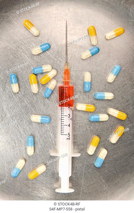 Syringe with red liquid and capsules