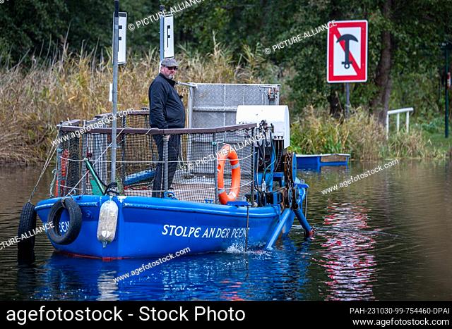PRODUCTION - 26 October 2023, Mecklenburg-Western Pomerania, Stolpe: Ferryman Ulf Radicke takes the small passenger ferry across the Peene