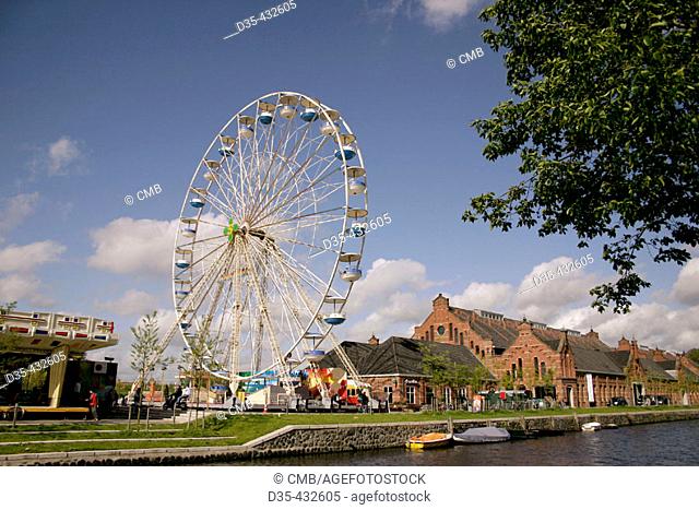 Cloudy sky. Bigwheel of fair near canal. Weterpark Kermis. Amsterdam. Holland