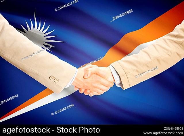 Businessmen shaking hands with flag on background - Marshall Islands