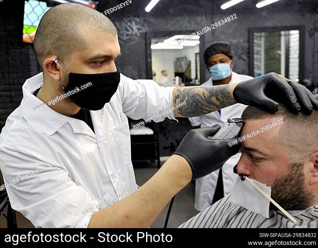 MURMANSK, RUSSIA - MAY 12, 2020: A man has his hair cut at the Mafiozi barbershop. Beauty, hair salons and barbershops reopen in Murmansk amid the COVID-19...