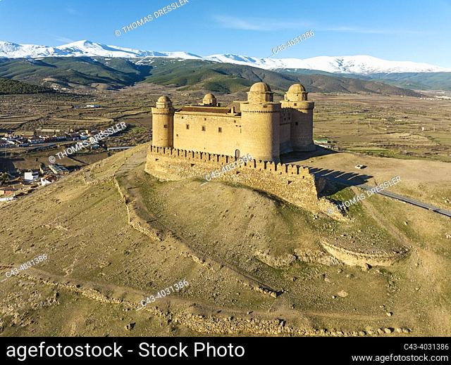 The Renaissance castle of La Calahorra against the snow-capped Sierra Nevada mountain range. Aerial view. Drone shot. Granada province, Andalusia, Spain