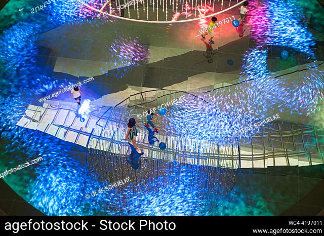 Singapore, Republic of Singapore, Asia - People walk over the interactive Digital Light Canvas (Digital art installation) by Teamlab at The Shoppes mall at...