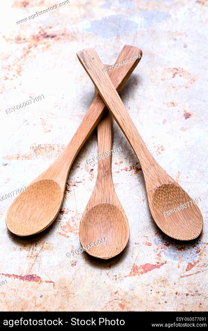 three brown wooden spoons on steel plate