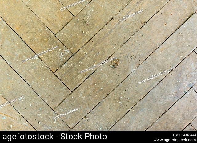 A close-up of an old gray faded parquet covered with dust and dirt. Result of repair. Cleaning and cleaning required