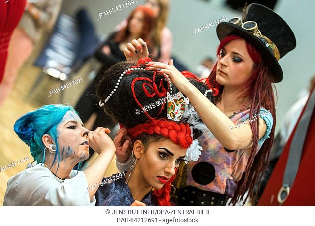 Model Tina, member of the team of the vocational college Rostock, is transformed into the Queen of Hearts from Alice in Wonderland by Lisa Meier (r) and Irina...